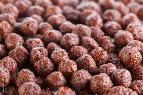 Chocolate corn balls isolated on white background. Chocolate balls dry breakfast scattered on a white background. Space for text. Also known as Chocolate flakes.