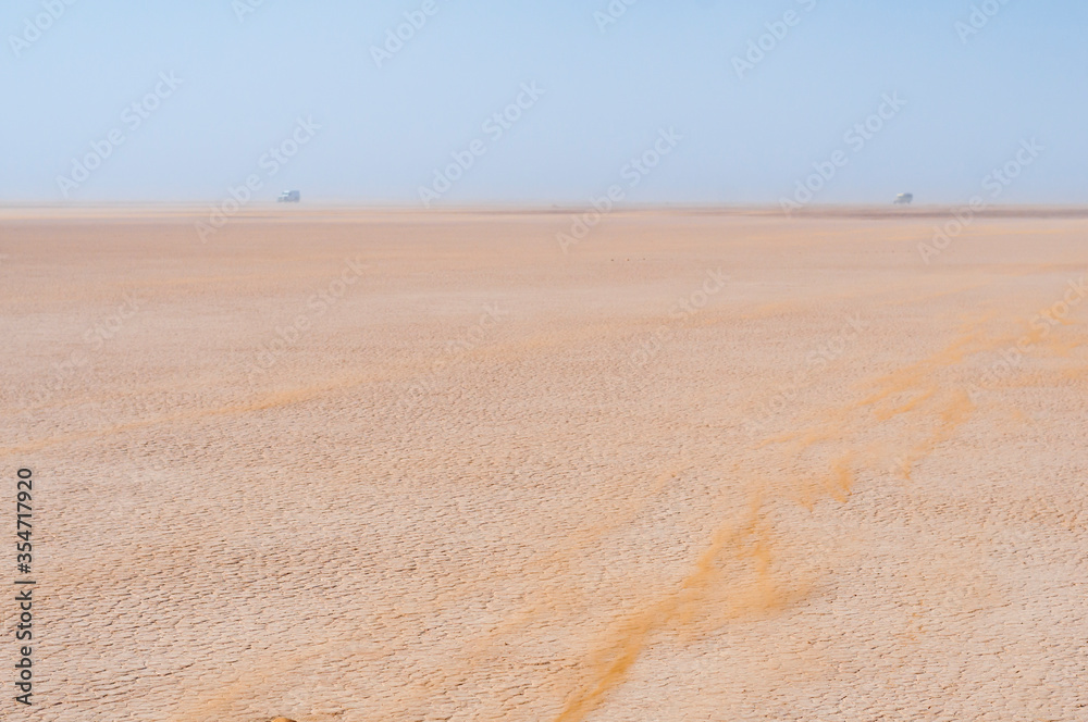 Off-road vehicle in a sandstorm / Cars drive in the sandstorm in the Sahara, on the Lac Iriki salt lake, Morocco, Africa. Off-road vehicle in a sandstorm / Cars drive in the sandstorm in the Sahara, on the Lac Iriki salt lake, Morocco, Africa.