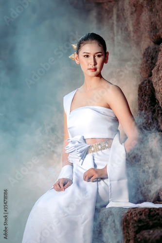 Beautiful thai woman In traditional Thai costume of Khmer times Sitting in a stone castle