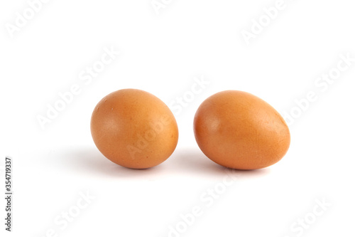 Two brown chicken eggs on white background