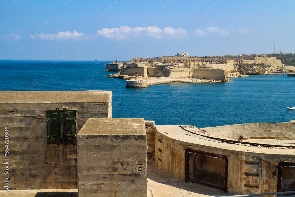 View of the Mediterranean Sea and defensive walls around the harbor area as seen from the fortifications of Valletta, Malta.