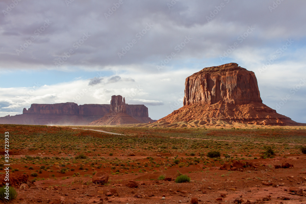 Scenic landscape of Monument Valley Tribal Park (Sentinel Mesa, West Mitten Butte and Merrick Butte) from below with clouds