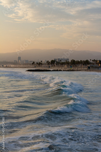 Los Angeles shoreline and Santa Monica with Palm trees and ocean waves at golden hour