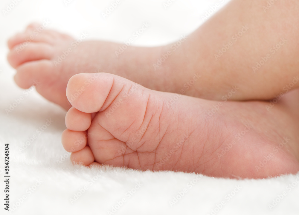Newborn baby feet on white blanket closeup Newborn baby feet on white blanket closeup