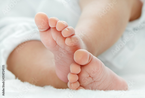 Newborn baby feet on white blanket closeup