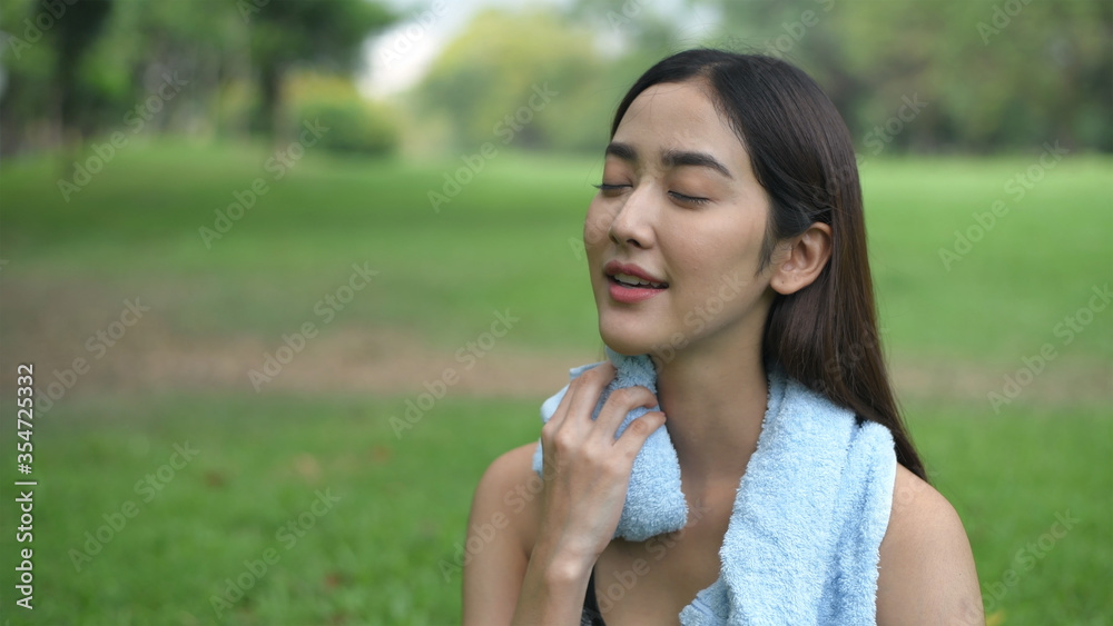 Holiday concept. Girl wiping sweat after exercising in the garden. 4k Resolution. Holiday concept. Girl wiping sweat after exercising in the garden. 4k Resolution.