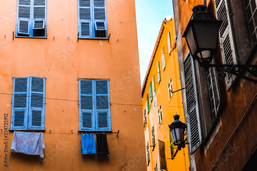 Old building facades with colorful shutters and laundry hanging outside in the historical center of Nice, French Riviera, southern France.  photo