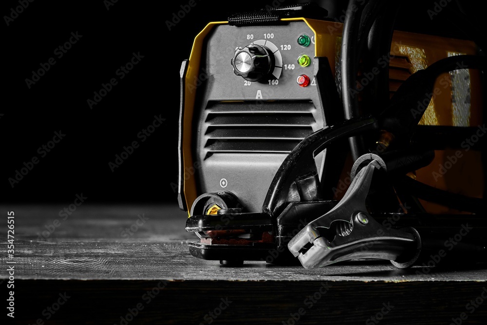 Inverter welding machine. Equipment for welding metals on a wooden desktop.