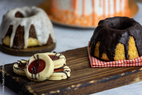 
sweet table breakfast snack with cake and pudding cup of tea or coffee with chocolate orange cake with cream and strawberry cookies photo