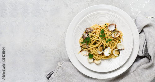 Obraz na płótnie food delivery from restaurants pasta with clams and parsley Spaghetti alle Vongole in white plates on a grey background
