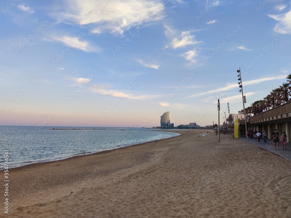 beach of Barceloneta a district of Barcelona during pandemic covid 19 coronavirus, seashore with the Hotel Vela, W Hotel, of the Catalan capital. Catalonia, Spain
