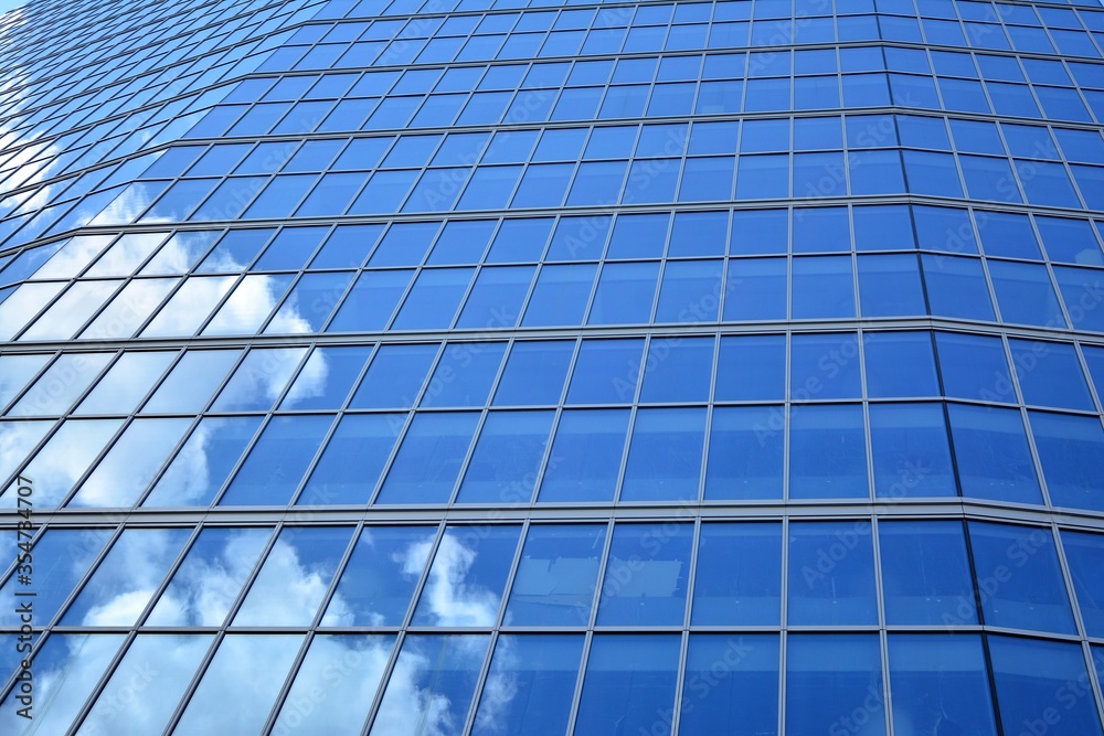 Facade texture of a glass mirrored office building. Fragment of the facade. Modern architecture of the office building. Facade texture of a glass mirrored office building. Fragment of the facade. Modern architecture of the office building.