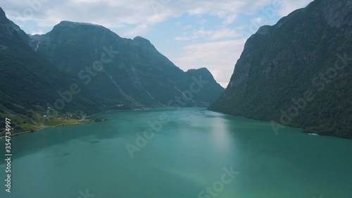 Scenery drone footage of a fjord in Norway with waterfalls on the mountains in the national park of jostedalsbreen