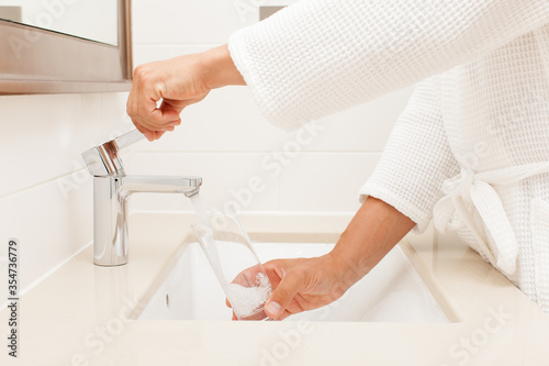 Fototapeta Naklejka Na Ścianę i Meble -  man arms closeup with glass water in bathroom