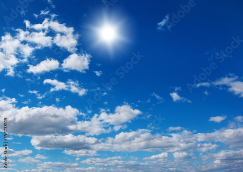 Blue sky with clouds and sun.