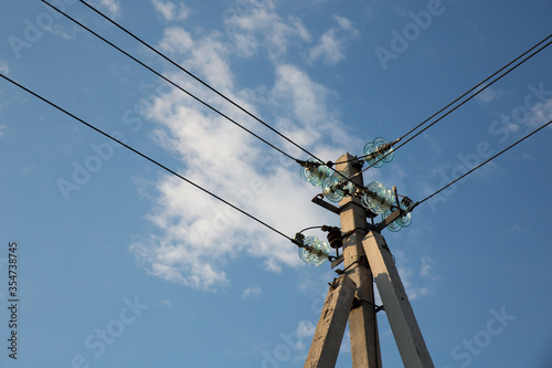 Power pole with electrical insulators against the sky