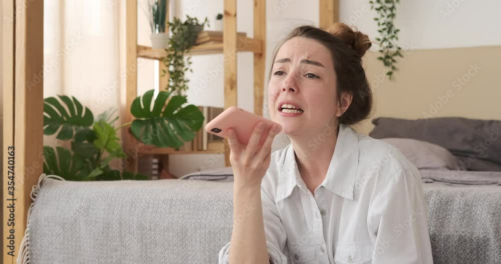 Woman recording voice message using mobile phone sitting at home Woman recording voice message using mobile phone sitting at home