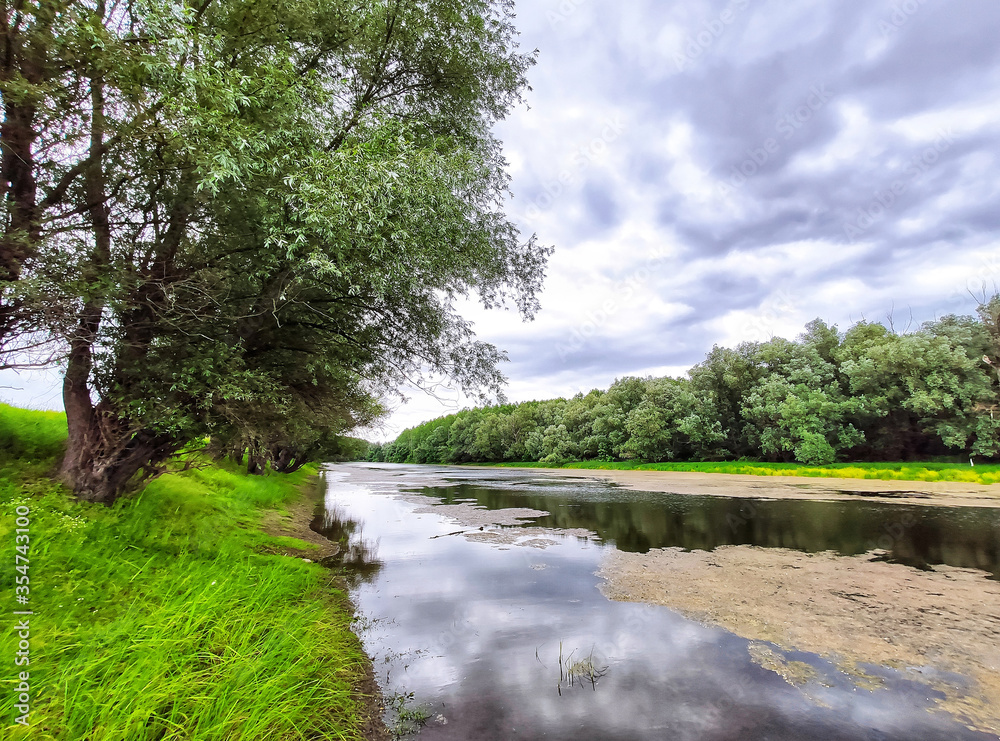 River, green trees and dramatic sky River, green trees and dramatic sky