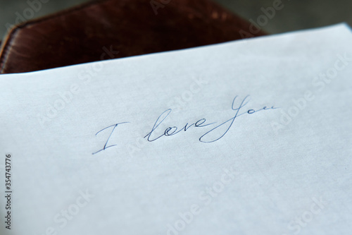 The phrase "I love you", handwritten with a beautiful underline on a squared notebook sheet. Manifestation of love and feelings. 