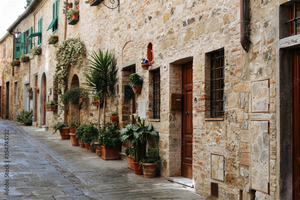 Obraz premium Ancient Italian street.Streets of Italy.Medieval street with flowers.Stone houses, flower lane. Old beautiful Tuscan streets in the Italian town.