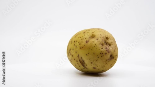 Yukon gold potato spinning with a white background. 