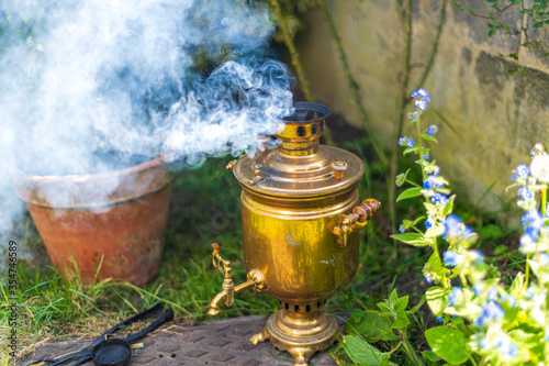Old vintage samovar with smoke. Brewing tea in the old fashioned way. Russian ceremony