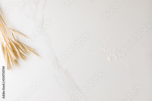 Top view of a marble table with wheat and flour with space for text