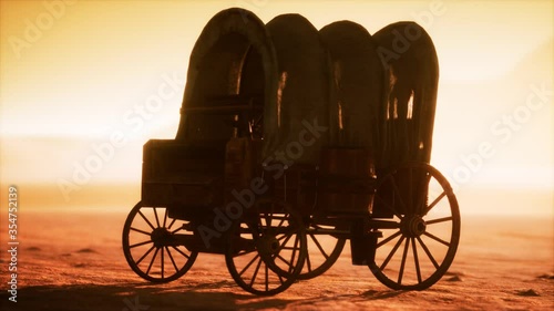 canvas covered retro wagon in desert at sunset photo