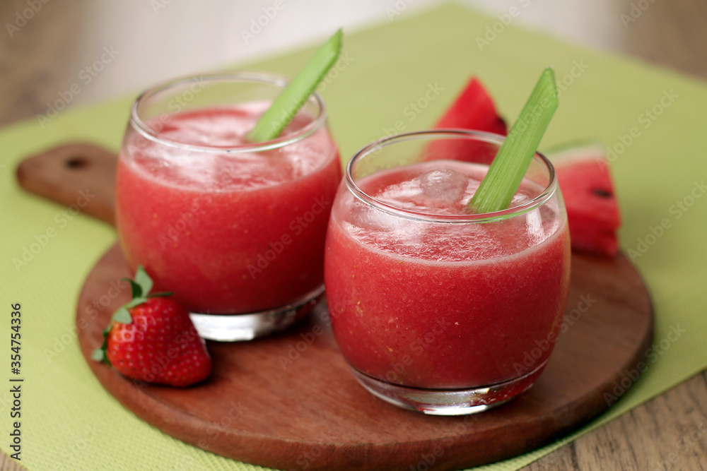 Refreshing strawberry watermelon juice served with ice and celery Refreshing strawberry watermelon juice served with ice and celery