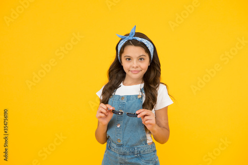 Snack for productivity. little beauty at hairdresser. love her retro fashion style. summer vacation. summer shopping sales. pin up kid. happy childrens day. cheerful vintage girl on yellow background photo