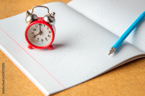 Back to school concept. old alarm clock on a clean notebook. Copy space.