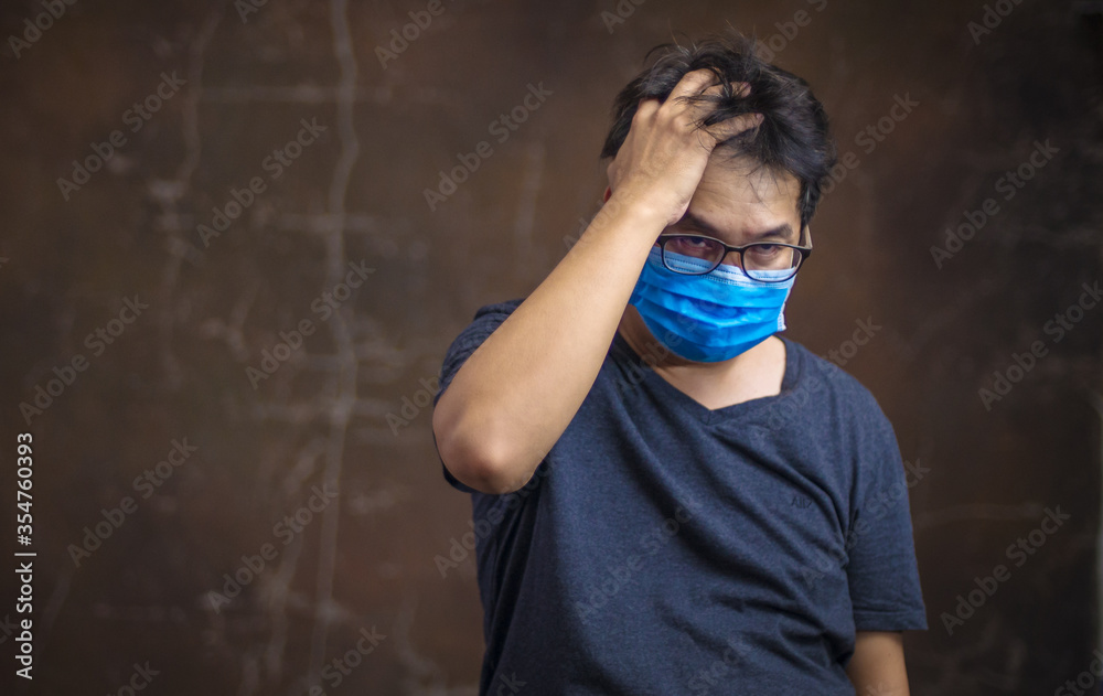 Corona virus, or Covid-19, is spreading all over the world. Portrait of an Asian Man wearing a black oil mask, anti-virus, or anti-Covid-19. Feeling stressed Corona virus, or Covid-19, is spreading all over the world. Portrait of an Asian Man wearing a black oil mask, anti-virus, or anti-Covid-19. Feeling stressed