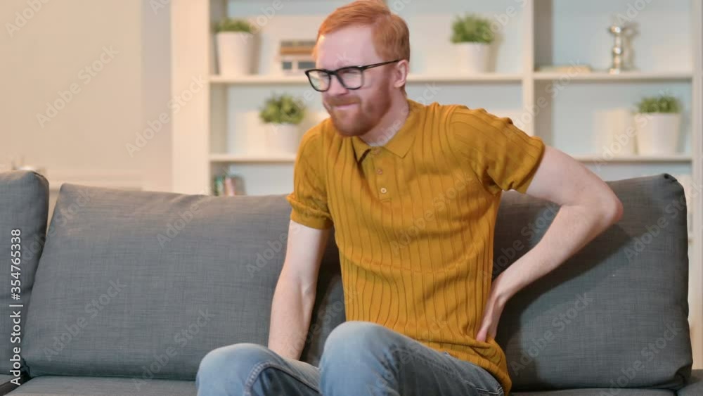 Attractive Redhead Man having Back Pain at Home Attractive Redhead Man having Back Pain at Home