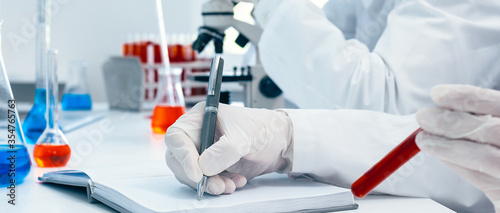 close up. a scientist making an entry in a laboratory journal.