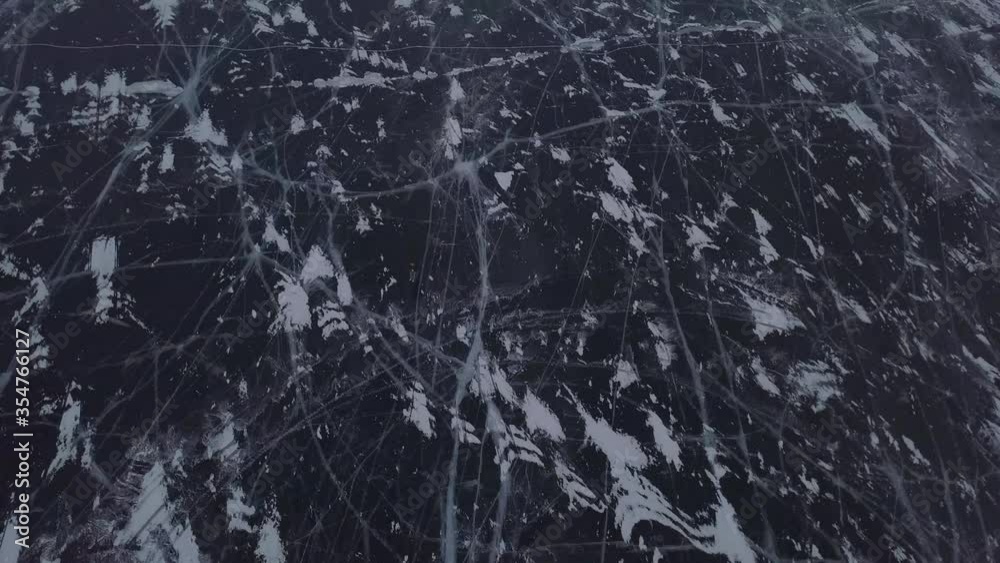 Aerial view of two cars standing on frozen lake Baikal near Shamanka mount. Beautiful patterns on ice. Khuzhir, Olkhon island, Siberia, Russia. Aerial view of two cars standing on frozen lake Baikal near Shamanka mount. Beautiful patterns on ice. Khuzhir, Olkhon island, Siberia, Russia.