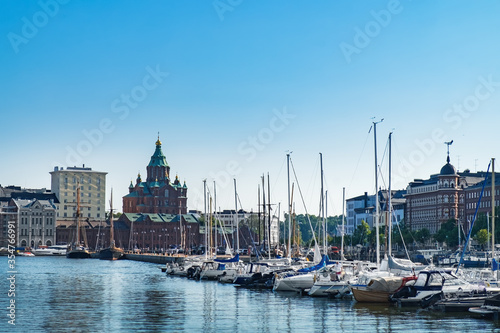 Scenic Finnish cityscape of Scandinavian Old Town pier with Uspenski Cathedral, old boats and sailing ship in sea harbor. Katajanokka district is famous tourist destination in Helsinki city, Finland © sonatalitravel