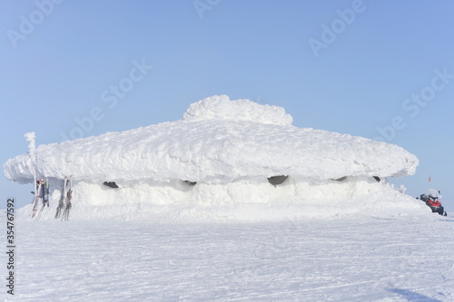 Hexagonal building at a mountain summit is nearly snowed under. © Rhys