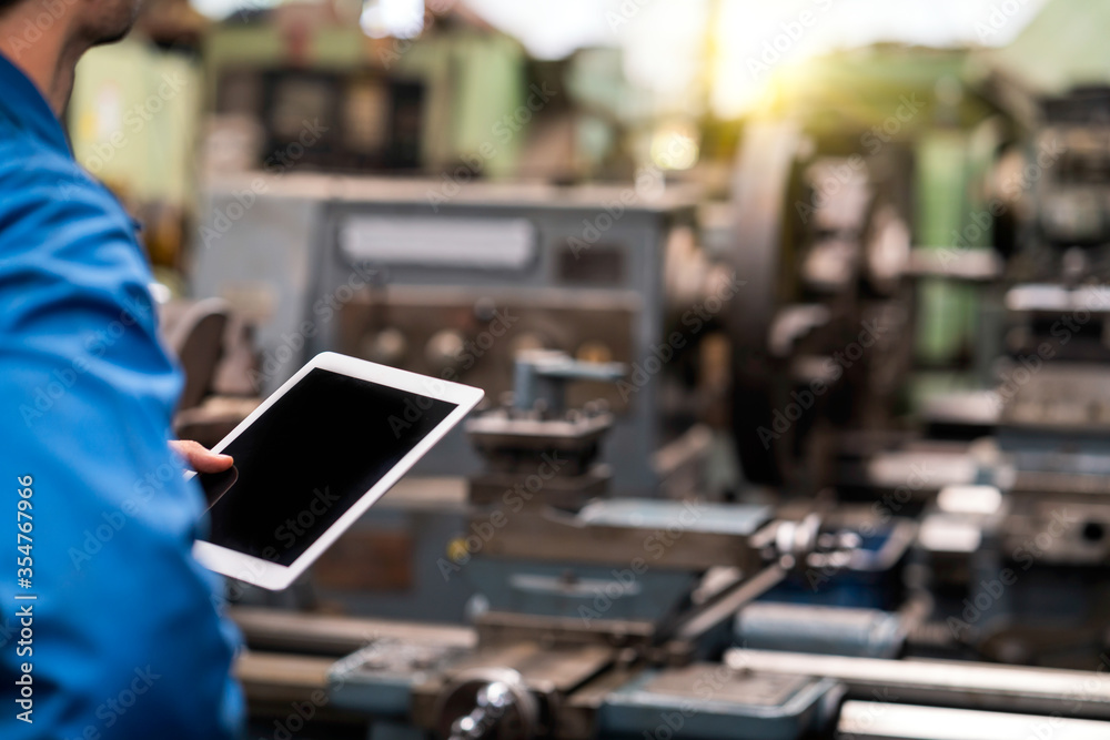 Selective focus. Professional technicians are checking the system of the machine with a tablet. Engineers and skilled technicians are maintaining machinery. Selective focus. Professional technicians are checking the system of the machine with a tablet. Engineers and skilled technicians are maintaining machinery.