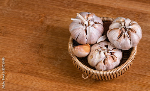 garlic bulb in wooden bowl place on background Concept of healthy food