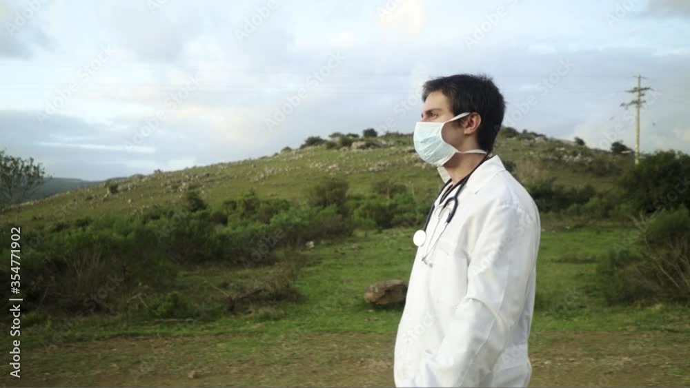 Doctor walking with protective mask on rural dirt road Doctor walking with protective mask on rural dirt road