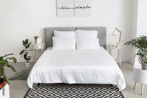 Big comfortable bed with clean linen in room