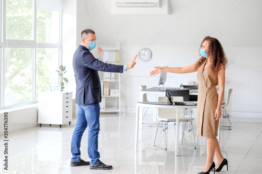 Fototapeta premium Colleagues greeting each other in office. Concept of coronavirus epidemic