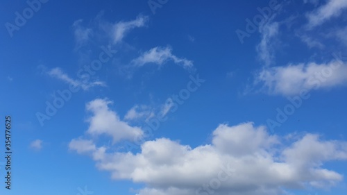 Clear blue sky with fluffy clouds in New Zealand. Aotearoa is the Maori name for New Zealand where is the land of the long white cloud. Empty space for text.
