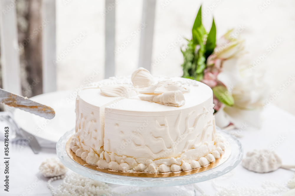Wedding cake decorated for bride and groom to cut during tropical destination caribbean wedding marriage outdoor ceremony on the sandy beach in Dominican republic Wedding cake decorated for bride and groom to cut during tropical destination caribbean wedding marriage outdoor ceremony on the sandy beach in Dominican republic