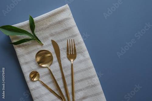 Beautiful silverware set on a blue table, top view with copy space photo