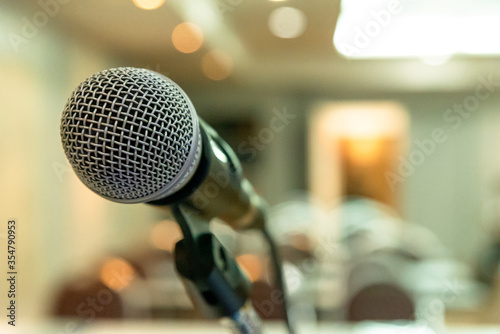 Microphone on abstract blurred background of seminar room or speaking conference.