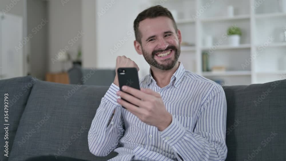 Ambitious Young Man Celebrating Success on Smart Phone Ambitious Young Man Celebrating Success on Smart Phone