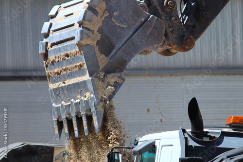 Φωτογραφία Bulldozer attachment unloading sand onto the back of a truck