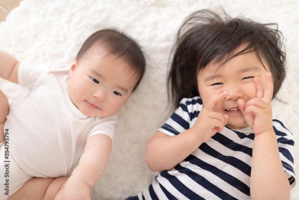 リビングのカーペットの上で遊ぶ姉妹 リビングのカーペットの上で遊ぶ姉妹