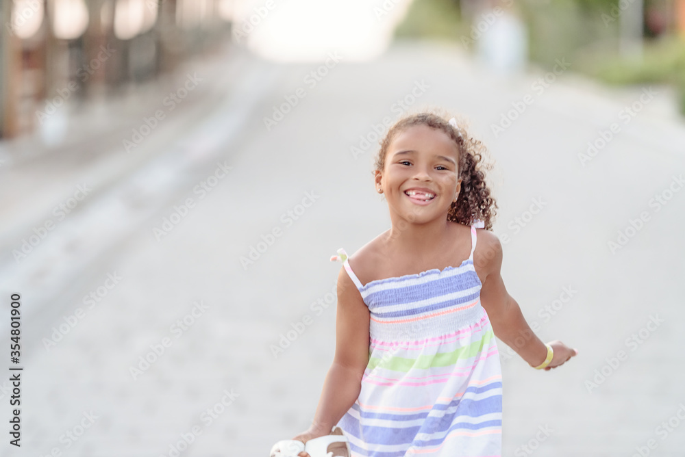 Adorable happy smiling little girl on beach vacation.